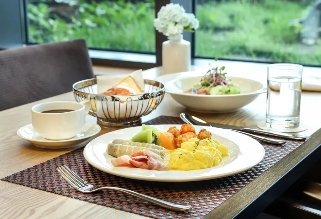 Une table est dressée avec un petit-déjeuner copieux et une boisson chaude.