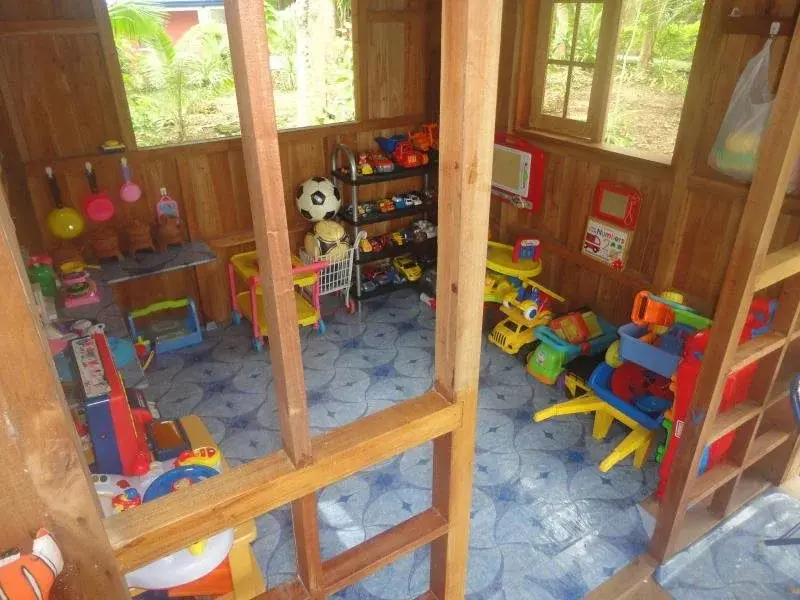 Espace de jeux pour enfants avec des jouets et une petite cuisine.