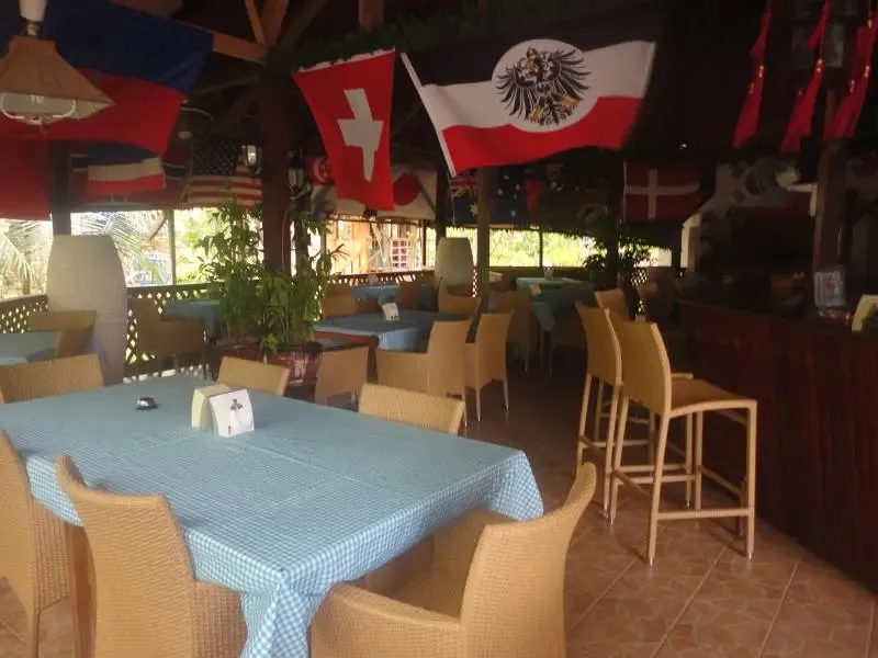 Une salle de restaurant avec des tables et des chaises sous des drapeaux.