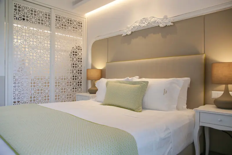 Un lit double est dispose dans une chambre lumineuse et decorée.