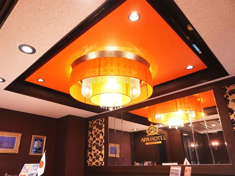 Un luminaire décoratif illumine un comptoir d'accueil.
