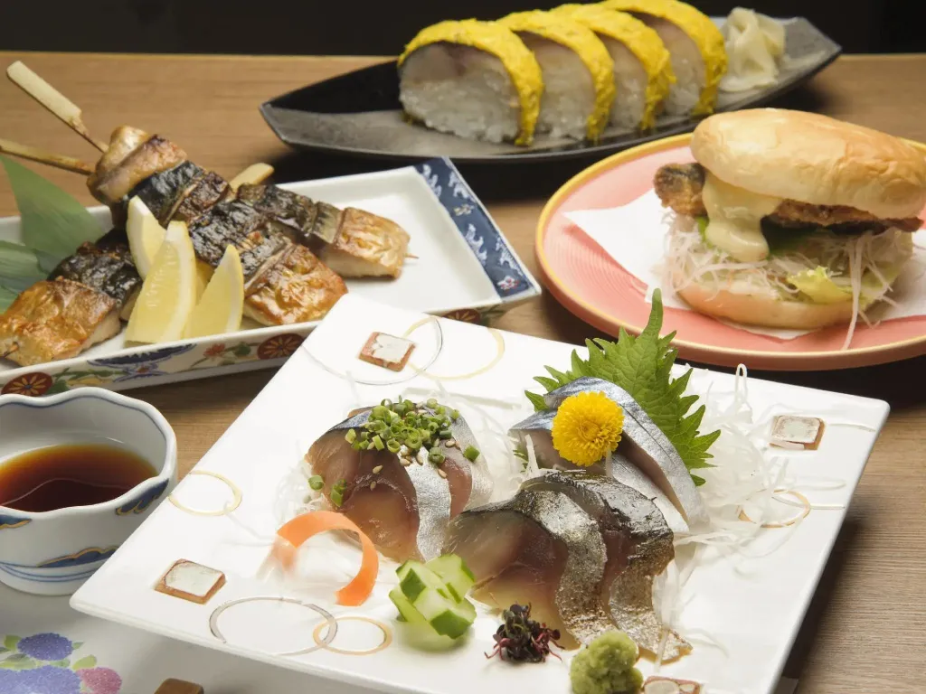 Assortiment de plats japonais présentés sur une table en bois.