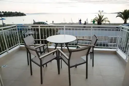 Une table ronde et des chaises composent un espace de repas sur une terrasse.