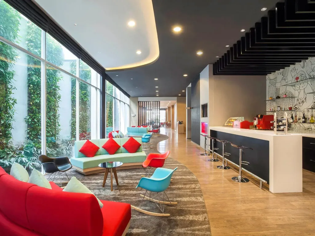 Un espace de détente intérieur avec des canapés colorés et un comptoir de bar.