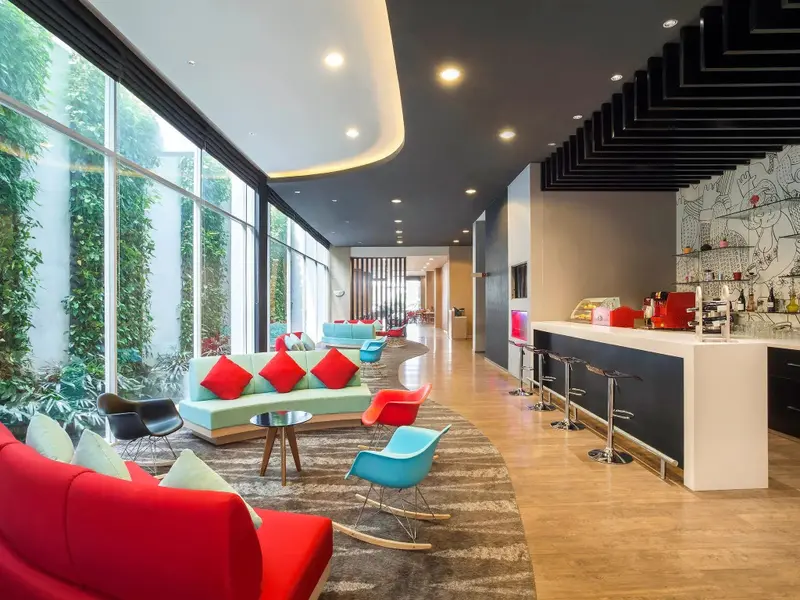 Un espace de détente intérieur avec des canapés colorés et un comptoir de bar.