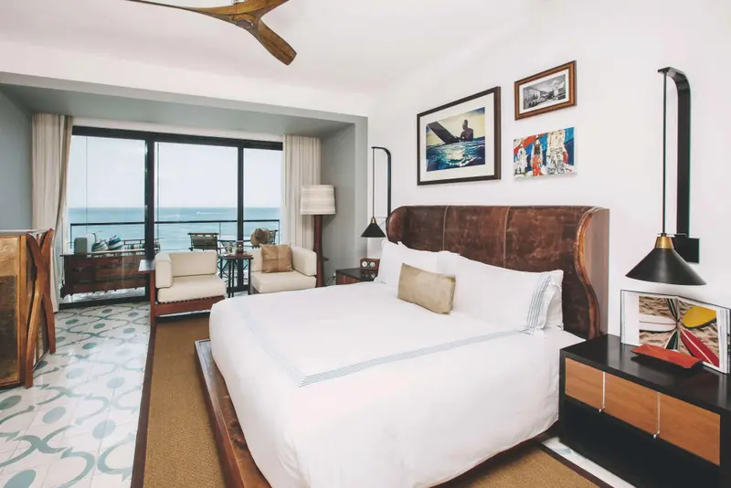 Une chambre lumineuse avec un grand lit et une vue sur la mer.