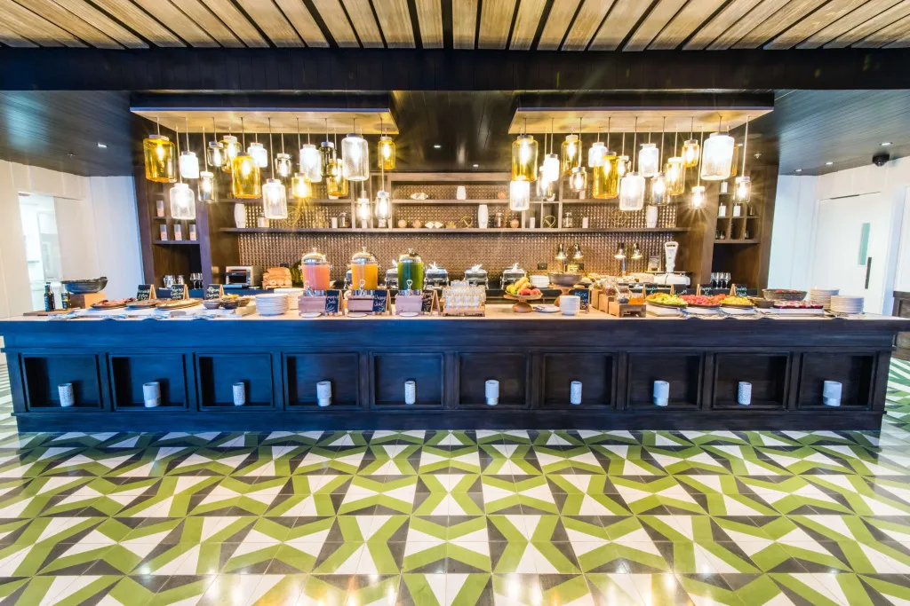 Un buffet propose une variété de plats et de boissons dans une salle lumineuse.