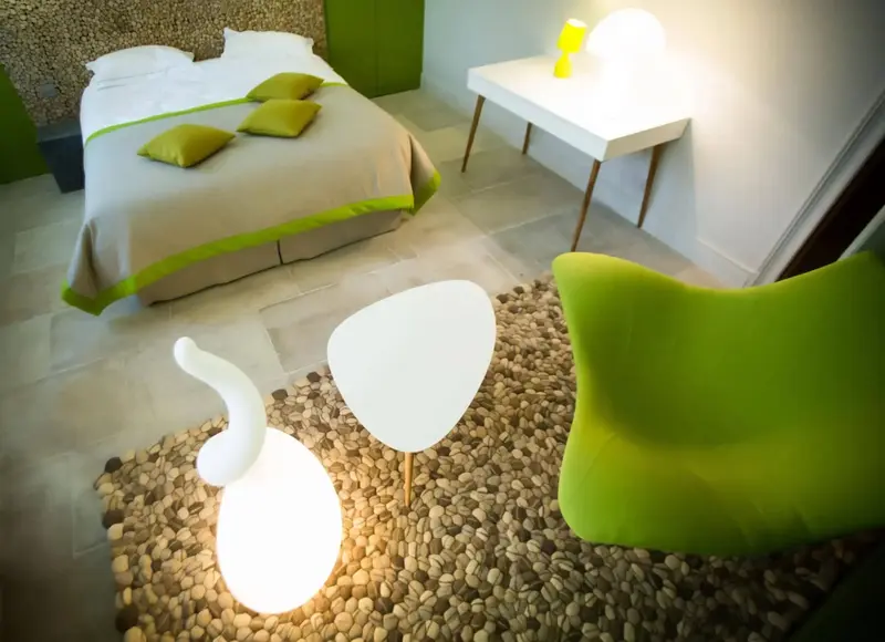 Une chambre lumineuse avec un lit blanc et des touches de vert.