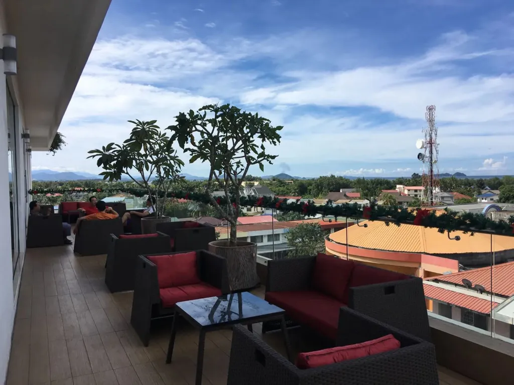 Espace de détente extérieur avec mobilier confortable et vue sur la ville.