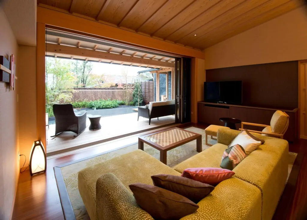 Espace de détente intérieur avec canapés et accès à une terrasse.
