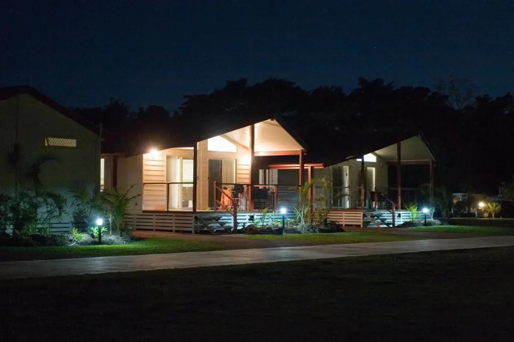 Des bungalows éclairés au crépuscule avec des terrasses en bois.