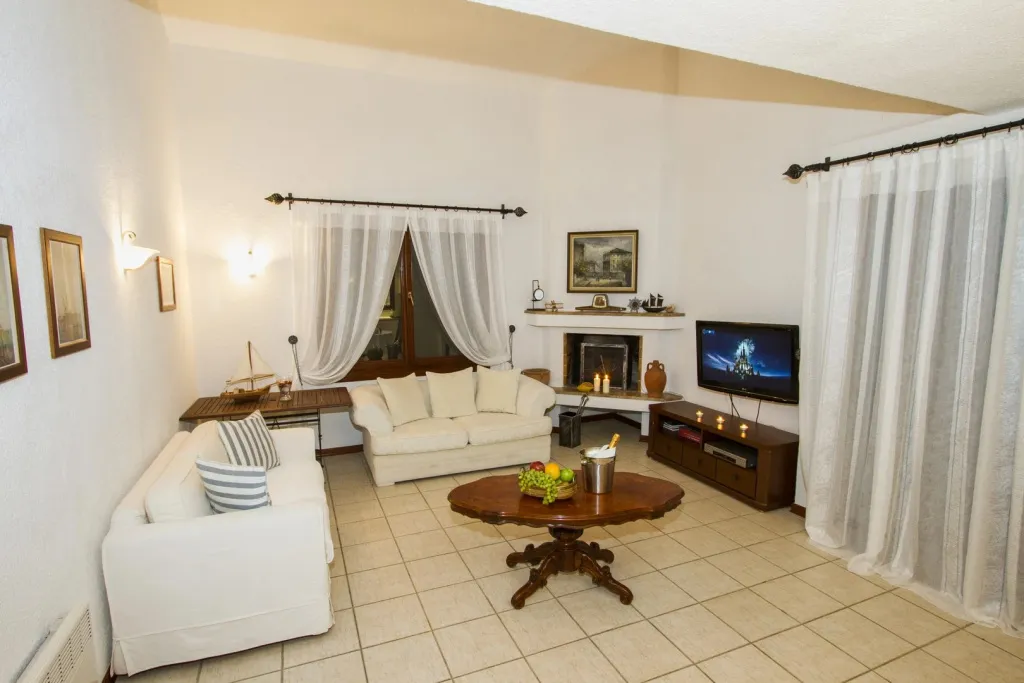 Espace de détente lumineux avec canapés et télévision.