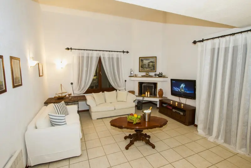 Espace de détente lumineux avec canapés et télévision.