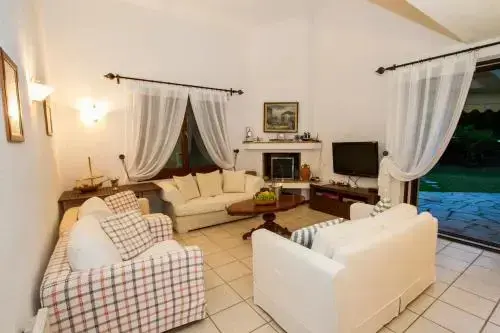 Un salon clair et spacieux avec canapés et une télévision.