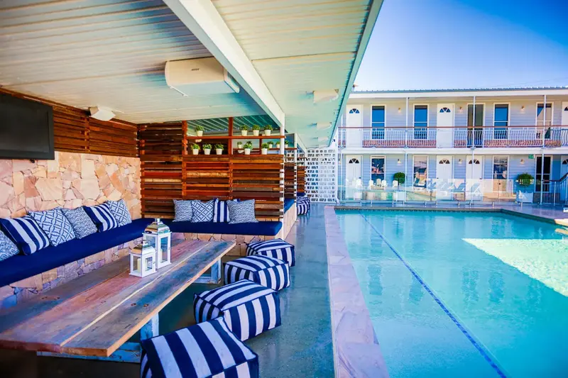 Espace de détente extérieur avec mobilier confortable près d'une piscine.