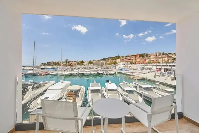 Vue sur un port de plaisance ensoleillé depuis un intérieur clair.