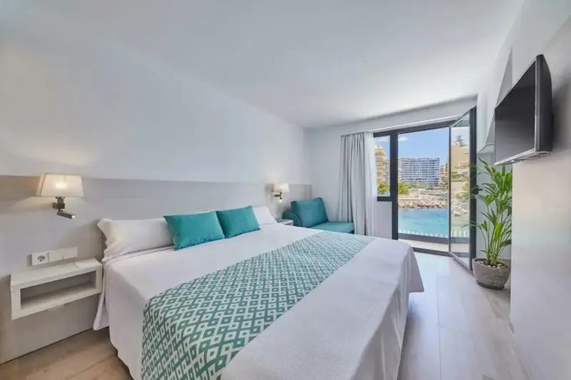 Une chambre lumineuse avec un grand lit et un accès à une terrasse.
