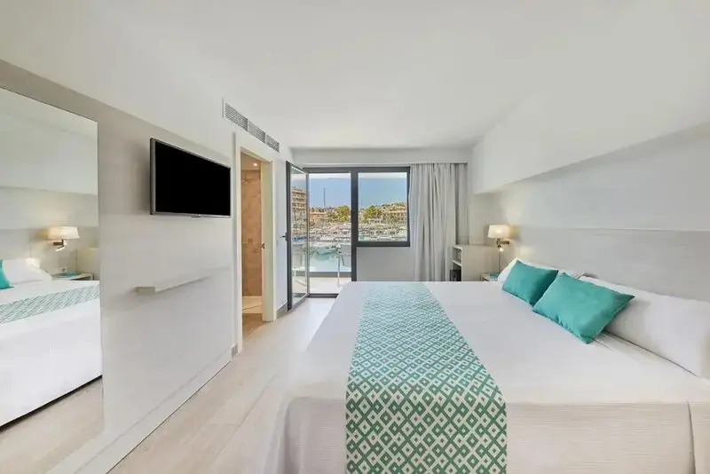 Une chambre lumineuse avec un grand lit et un accès à un balcon.