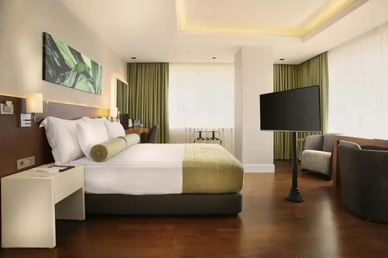 Une chambre d'hotel moderne avec un grand lit et un fauteuil.
