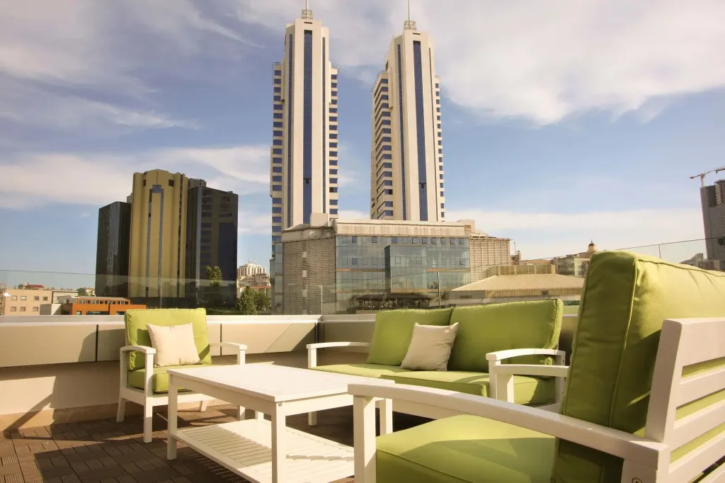 Mobilier d'extérieur sur une terrasse avec vue sur des bâtiments.