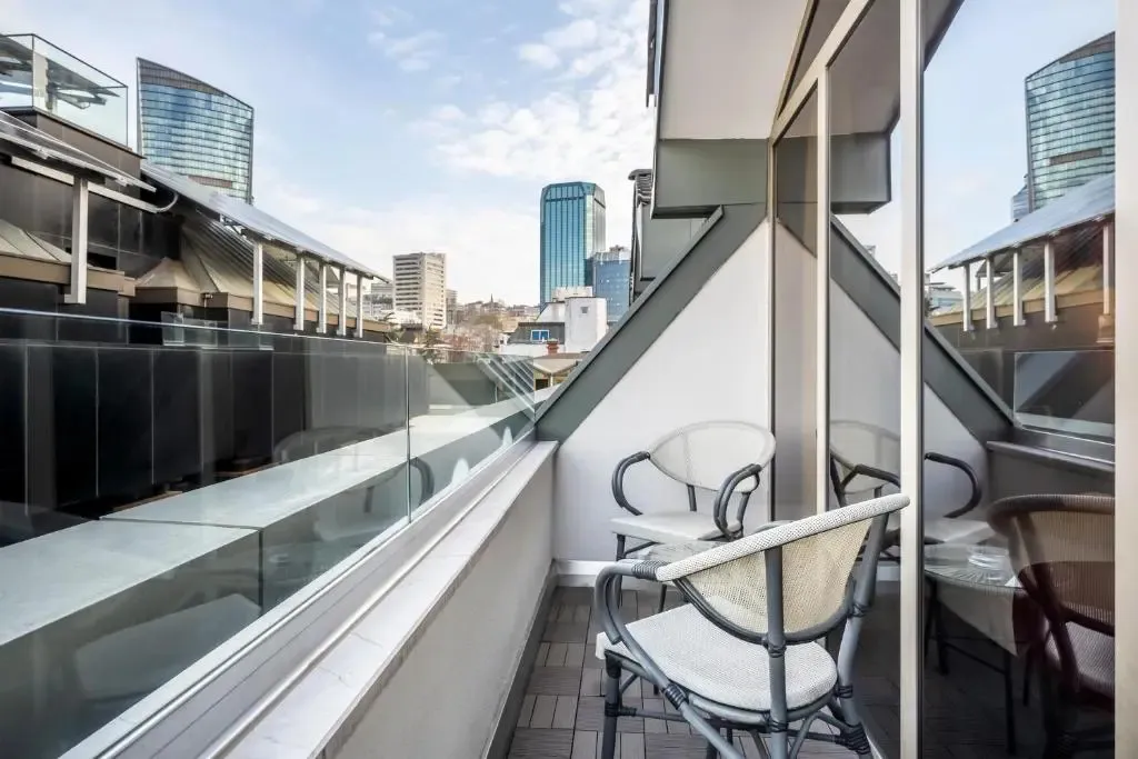 Une terrasse avec des meubles de jardin offre une vue sur la ville.