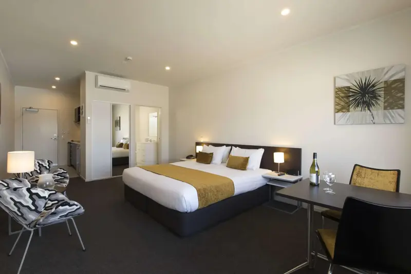 Une chambre lumineuse avec un grand lit et un coin repas.