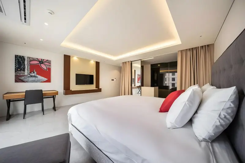 Une chambre lumineuse avec un grand lit et un bureau.