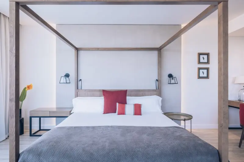 Une chambre lumineuse avec un grand lit à baldaquin et des tables de chevet.