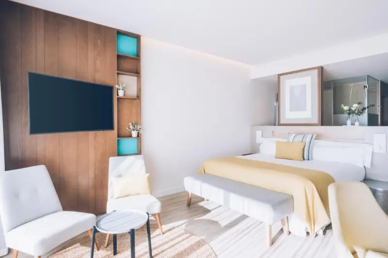 Une chambre lumineuse avec un grand lit et un coin salon.