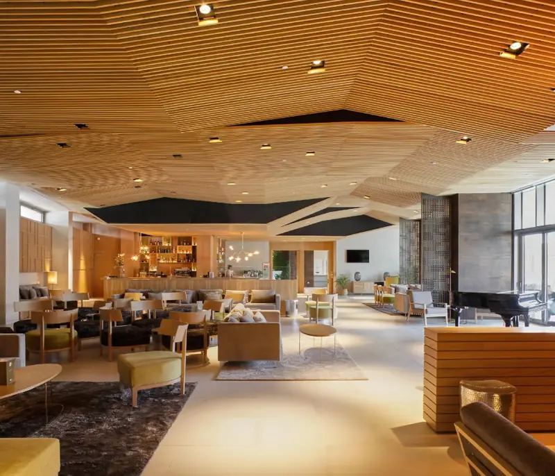 Un espace de détente intérieur lumineux avec des canapés et un comptoir de bar.