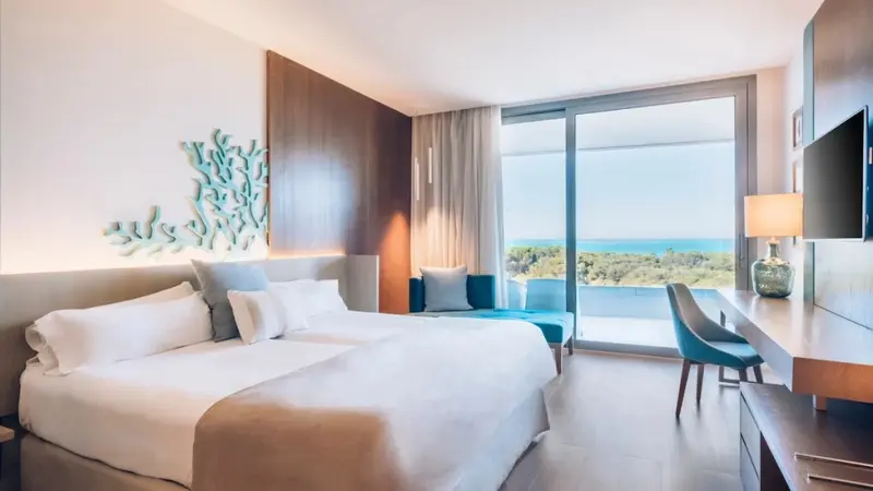Une chambre lumineuse avec un grand lit et une vue sur la mer.