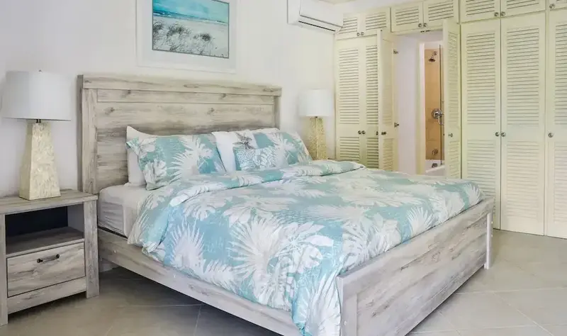 Une chambre lumineuse avec un grand lit recouvert d'une couette à motifs.