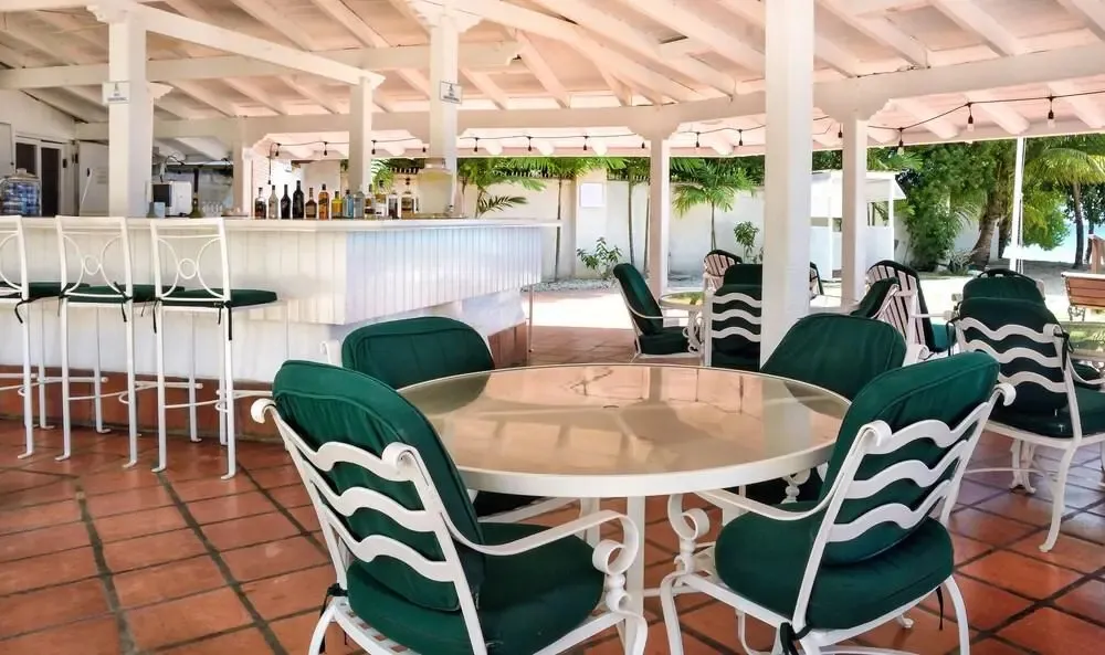 Un espace extérieur abrité avec un bar et des tables à manger.