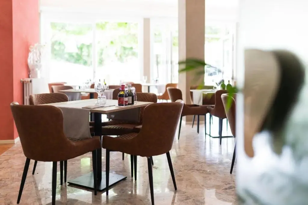 Une salle lumineuse avec des tables dressées pour le repas.