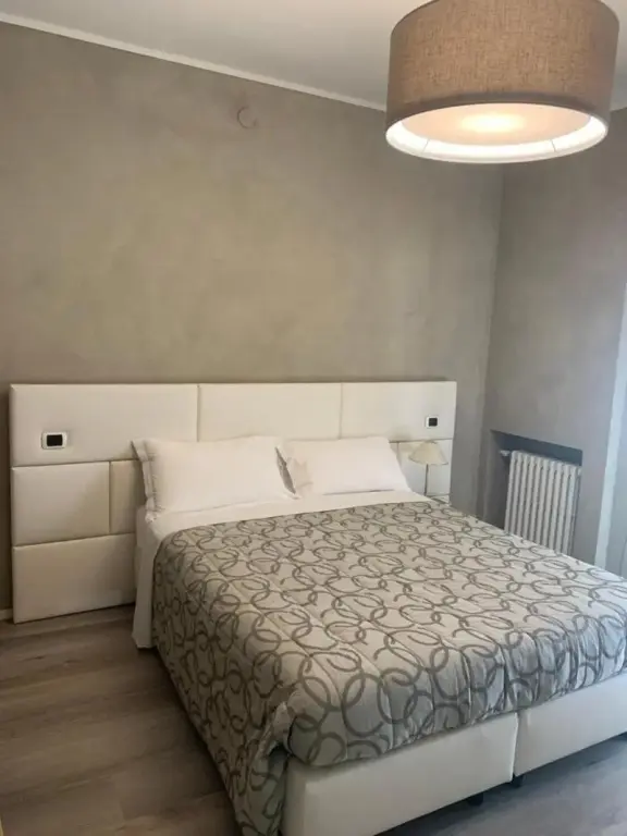 Une chambre lumineuse avec un grand lit recouvert d'une couverture à motifs.