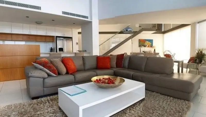 Un grand canapé gris dans un espace de vie lumineux et moderne.