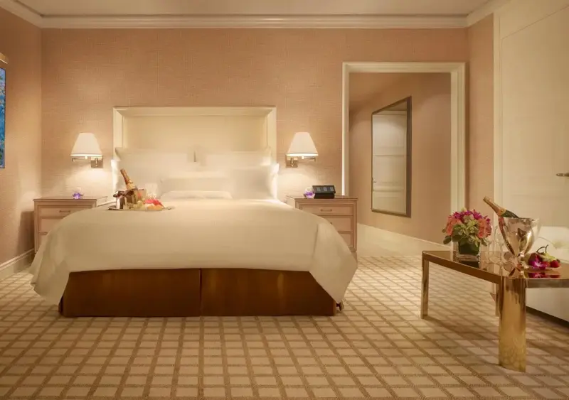 Une chambre à coucher lumineuse avec un grand lit recouvert d'une courtepointe blanche.