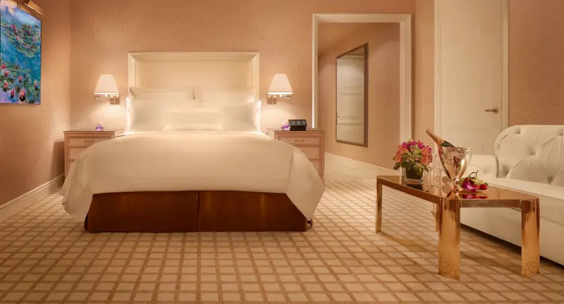 Une chambre lumineuse avec un grand lit et un coin salon.