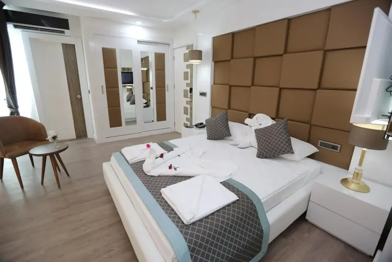 Une chambre lumineuse avec un grand lit et un coin salon.