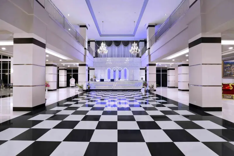 Vaste hall d'entrée avec sol à carreaux et comptoir d'accueil.