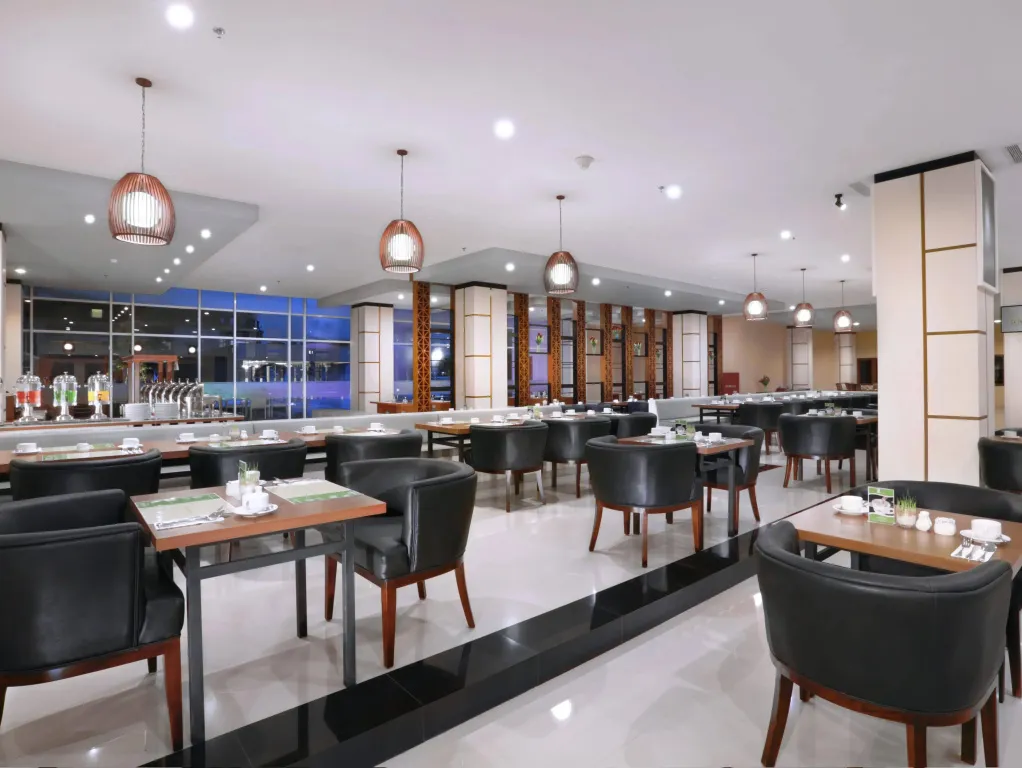 Une salle lumineuse avec des tables dressées pour le repas.