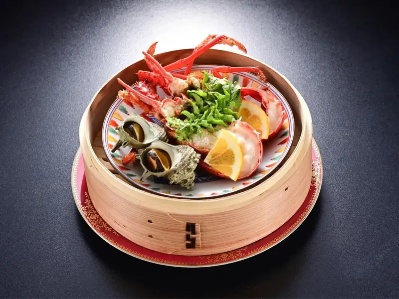 Présentation raffinée de fruits de mer et de légumes sur une assiette décorative.
