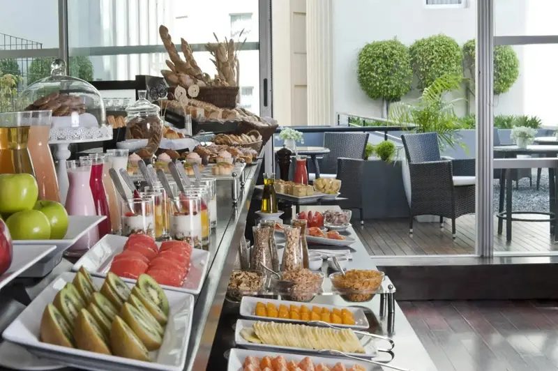 Un buffet propose une variété de pâtisseries, de fruits et de boissons.