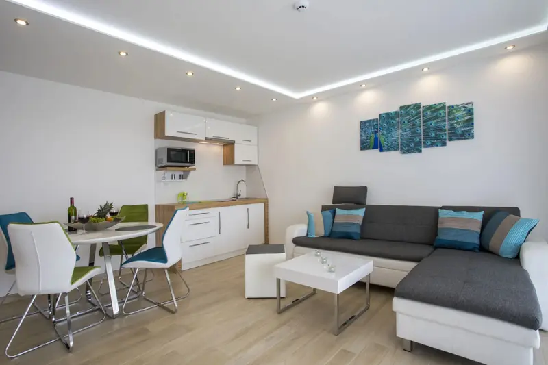 Espace de vie lumineux avec coin repas et cuisine équipée.