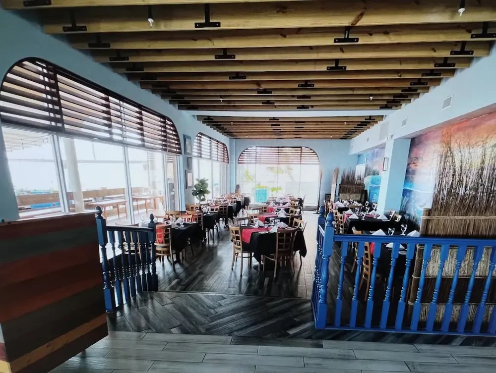 Une salle lumineuse avec des tables dressées pour un repas.