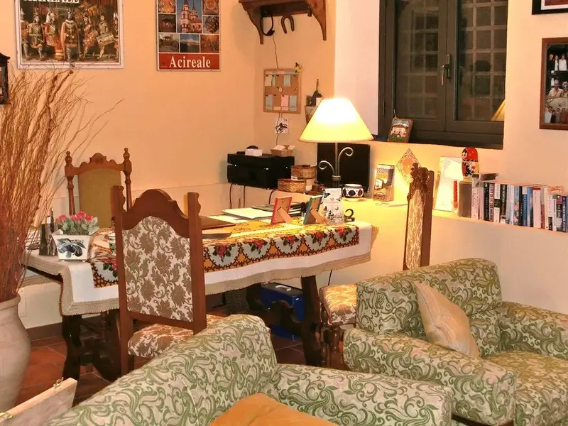 Une salle à manger lumineuse avec une table dressée et des fauteuils confortables.