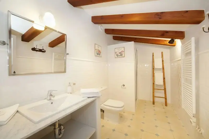 Une salle de bain lumineuse avec douche et lavabo.