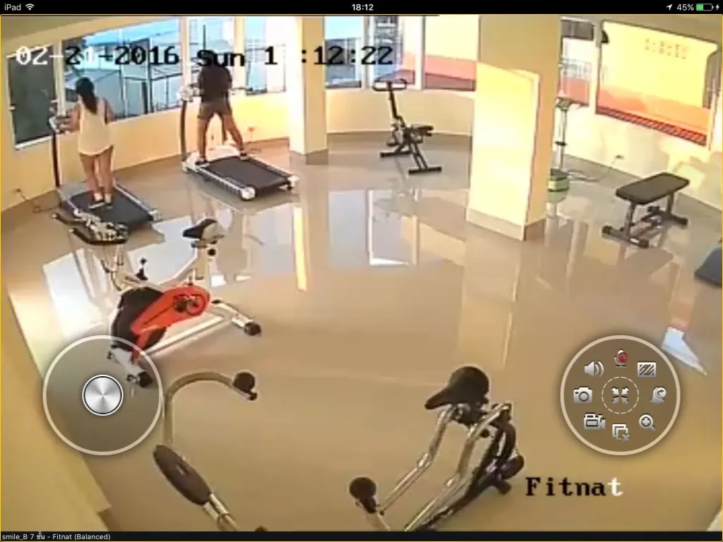 Une salle lumineuse avec des équipements de fitness et des personnes s'entraînant.