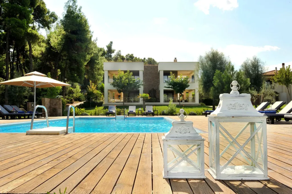 Terrasse en bois avec piscine et bâtiment à l'arrière-plan.