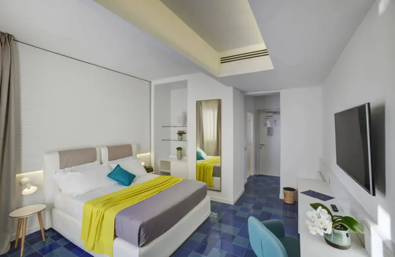 Une chambre lumineuse avec un grand lit et une télévision à écran plat.